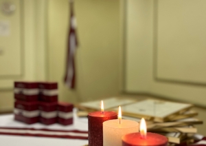 Valsts svētku pasākums. Izgreznots galdas ar sarkanbalsarkanām svecēm, konfektēm un Atzinības rakstiem.